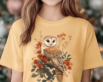 May include: A yellow t-shirt with a white barn owl perched on a branch with red berries. The owl has a white face and brown and white feathers. The text "Comfort Colors Mustard" is visible in the lower left corner of the image.