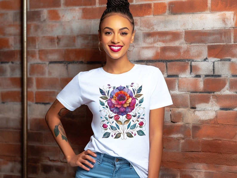 May include: A white t-shirt with a colorful floral design featuring a large flower with pink, purple, and orange petals. The design is surrounded by green leaves and vines.
