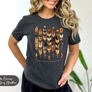 May include: Dark grey heather Bella Canvas t-shirt with a graphic of colorful feathers and the text "Feathers appear when angels are near."