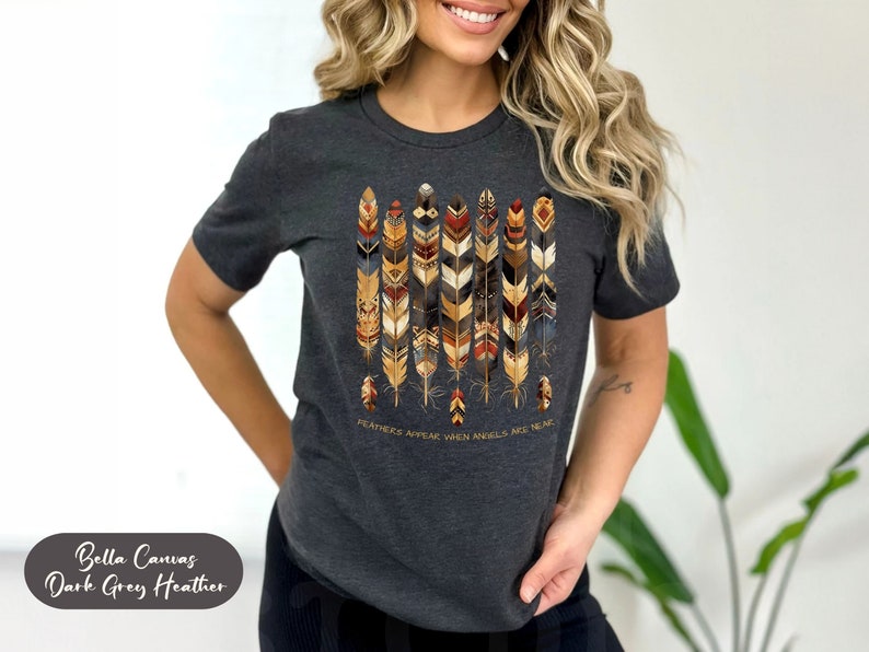 May include: Dark grey heather Bella Canvas t-shirt with a graphic of colorful feathers and the text "Feathers appear when angels are near."