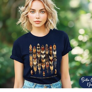 May include: A navy blue t-shirt with a graphic of colorful feathers and the text "Feathers appear when angels are near".