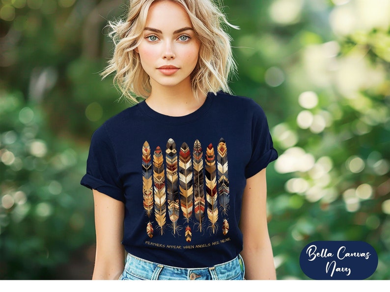 May include: A navy blue t-shirt with a graphic of colorful feathers and the text "Feathers appear when angels are near".