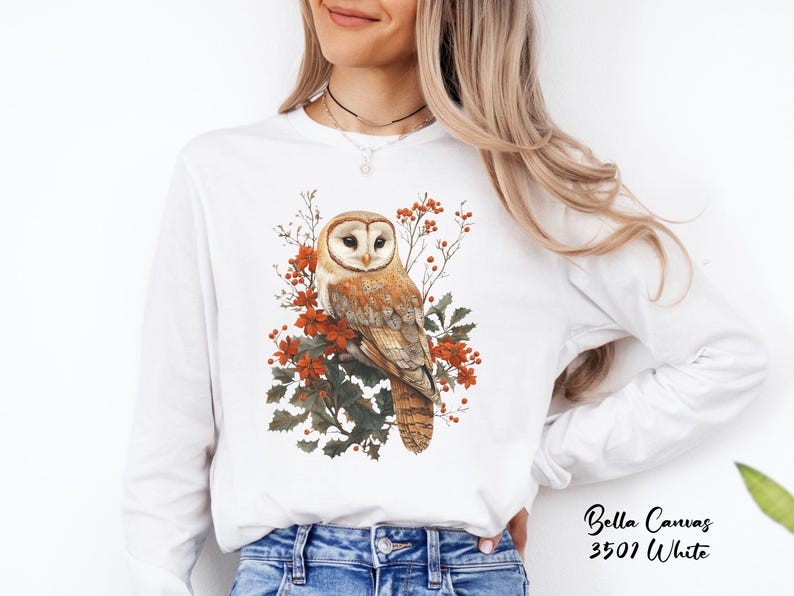 May include: White long-sleeve shirt with a brown and white barn owl perched on a branch with red berries and green leaves.