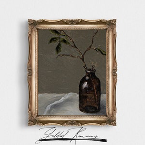 May include: A framed painting of a brown glass bottle with a single branch of leaves in it. The bottle is sitting on a white cloth. The painting is signed "Gilded Remains".