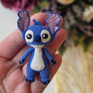 Handmade mini amigurumi Stitch doll crocheted with blue and white yarn, cute miniature crochet toy held in hand