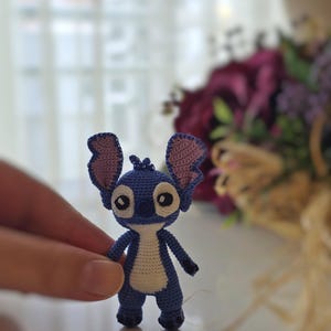 Handmade mini amigurumi Stitch doll crocheted with blue and white yarn, cute miniature crochet toy held in hand