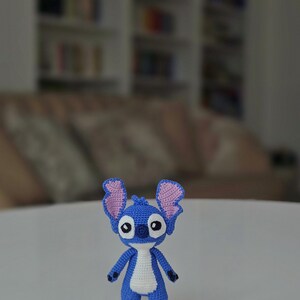 Handmade mini amigurumi Stitch doll crocheted with blue and white yarn, cute miniature crochet toy held in hand