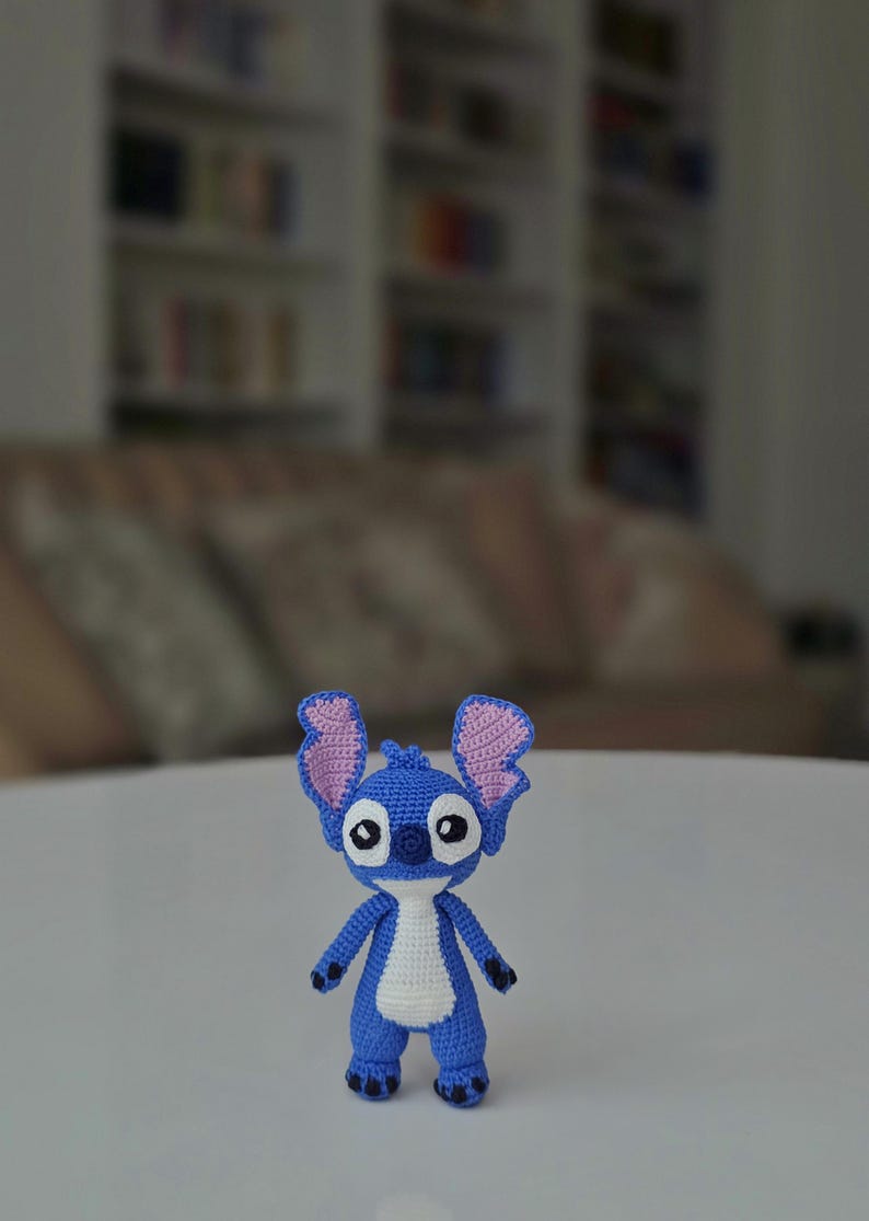 Handmade mini amigurumi Stitch doll crocheted with blue and white yarn, cute miniature crochet toy held in hand