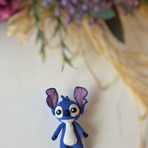 Handmade mini amigurumi Stitch doll crocheted with blue and white yarn, cute miniature crochet toy held in hand