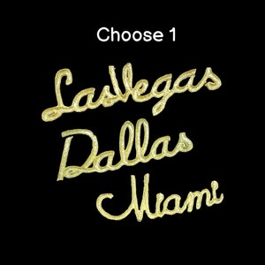 Peut inclure: Lettrage en paillettes dorées épellant "Las Vegas", "Dallas" et "Miami" sur un fond noir. Choisissez 1.