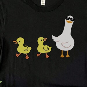BELLA AND CANVAS T SHIRT WITH A CUTE DESIGN OF TWO DUCKS AND THEN A GOOSE.  AVAILABLE IN DARK GREY HEATHER, HEATHER MAUVE, NAVY, BLACK, ATHLETIC HEATHER AND HEATHER SLATE.