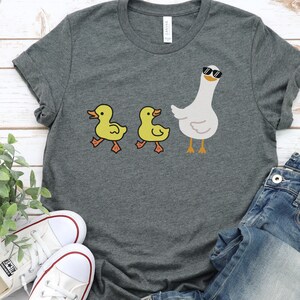BELLA AND CANVAS T SHIRT WITH A CUTE DESIGN OF TWO DUCKS AND THEN A GOOSE.  AVAILABLE IN DARK GREY HEATHER, HEATHER MAUVE, NAVY, BLACK, ATHLETIC HEATHER AND HEATHER SLATE.
