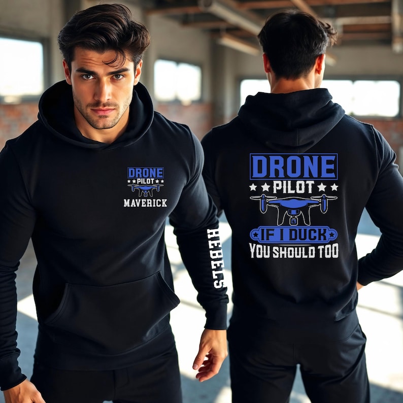 May include: Black hoodie with blue text that reads "DRONE PILOT" and "MAVERICK" on the front. The back of the hoodie has the text "DRONE PILOT" and "IF I DUCK YOU SHOULD TOO". The left sleeve has the word "HEBELS".
