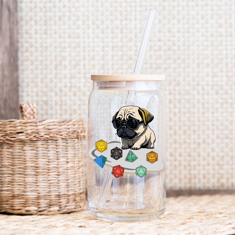 May include: A clear glass jar with a wooden lid and a straw. The jar has a sticker of a pug wearing sunglasses and standing on a circle of colorful dice.