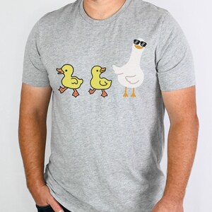 BELLA AND CANVAS T SHIRT WITH A CUTE DESIGN OF TWO DUCKS AND THEN A GOOSE.  AVAILABLE IN DARK GREY HEATHER, HEATHER MAUVE, NAVY, BLACK, ATHLETIC HEATHER AND HEATHER SLATE.