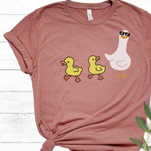 BELLA AND CANVAS T SHIRT WITH A CUTE DESIGN OF TWO DUCKS AND THEN A GOOSE.  AVAILABLE IN DARK GREY HEATHER, HEATHER MAUVE, NAVY, BLACK, ATHLETIC HEATHER AND HEATHER SLATE.
