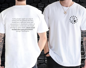 May include: White t-shirt with a quote by George Washington on the back and a silhouette of George Washington surrounded by stars on the front. The quote reads: "A free people ought not only be armed and disciplined, but they should have sufficient arms and ammunition to maintain a status of independence from any who might attempt to abuse them, which would include their own government." -George Washington