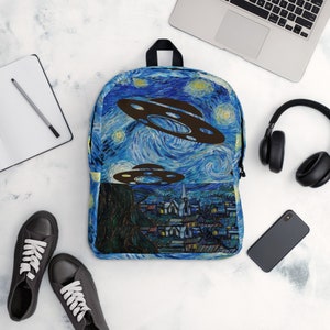 May include: A blue backpack featuring a starry night design with brown UFOs. The backpack has a black handle and straps. The design is reminiscent of Van Gogh's "Starry Night" painting.