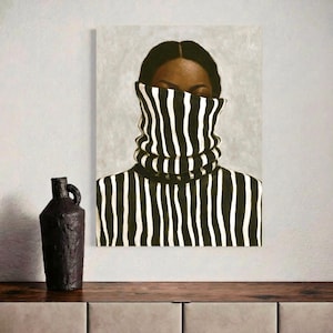 Op de afbeelding: Een rechthoekige canvasprint met een schilderij van een persoon in een zwart-wit verticaal gestreepte coltrui die de onderste helft van het gezicht bedekt. Naast het kunstwerk staat een donkere, getextureerde, cilindrische keramische vaas.