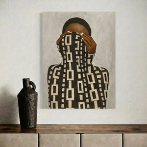 Op de afbeelding: Abstract schilderij van een persoon met hun gezicht bedekt door een zwart-wit geometrisch patroon. De persoon draagt een zwarte pet. Een donkere, getextureerde vaas met een handvat staat op een houten oppervlak.