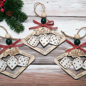 May include: Three wooden Christmas ornaments shaped like dice with the words "Bunco Babes", "Bunco" and "Bunco Beauties" written on them. Each ornament has the words "Good Times", "Good Laughs", and "Great Friends" written on it.