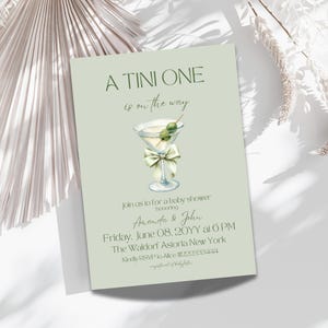 May include: A green and white baby shower invitation with a martini glass illustration and the text "A TINI ONE is on the way" and "join us to for a baby shower honoring Amanda & John Friday, June 08, 20YY at 6 PM The Waldorf Astoria New York Kindly RSVP to Alice 222333444"