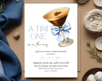 May include: A baby shower invitation with a blue and white martini glass with coffee beans on top. The text reads "A Tini One is on the way" and includes the date, time, and location of the event.