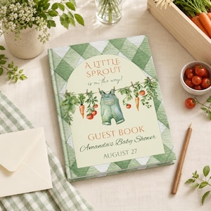 May include: A hardcover guest book with a green and white diamond pattern cover. The center features an arched label with the text A LITTLE SPROUT is on the way! GUEST BOOK Amanda's Baby Shower AUGUST 27, illustrated with hanging overalls and vegetables.