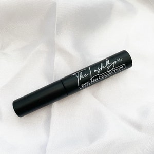 May include: A black tube of lash adhesive with white text that reads "The Lash Box Eyelash Collection".