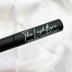 May include: A black tube with white text that reads "The Lash Box Eyelash Collection".