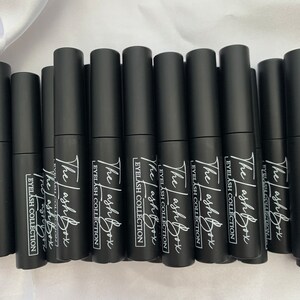 May include: Multiple black bottles with white text that reads "The Lash Box Eyelash Collection" on each bottle.