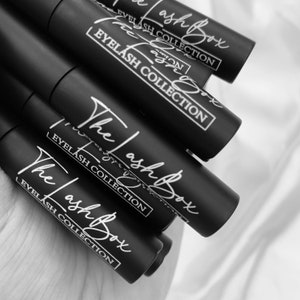 May include: Close-up of multiple black tubes with white text that reads "The Lash Box" and "Eyelash Collection".