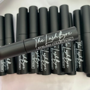 May include: Multiple black tubes with white text that reads "The Lash Box Eyelash Collection".