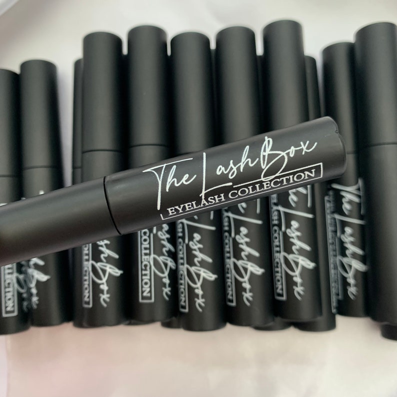 May include: Multiple black tubes with white text that reads "The Lash Box Eyelash Collection".