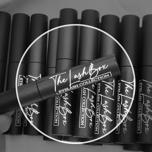 May include: Multiple black tubes with white text that reads "The Lash Box Eyelash Collection" on the labels.