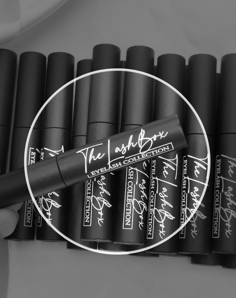 May include: Multiple black tubes with white text that reads "The Lash Box Eyelash Collection" on the labels.