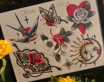 May include: A framed art print featuring traditional tattoo-style illustrations including a swallow, a butterfly, a rose inside a red heart, a floral sprig, a folding fan with a red rose, and a crescent moon with a sun, signed M Lisonbee 2026.