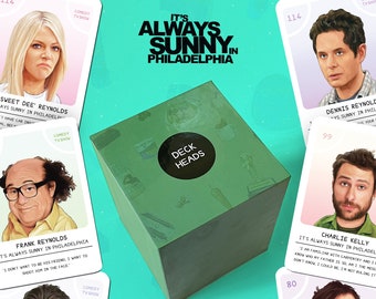May include: A green box labeled "Deck Heads" sits in the center of the image, surrounded by trivia cards featuring characters from the TV show "It's Always Sunny in Philadelphia." The box is part of an unofficial trivia game.