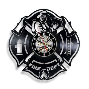 Puede incluir: Reloj de vinilo negro con diseño de bombero. El reloj presenta a un bombero con un hacha, una boca de incendios y las palabras "FIRE DEPT".