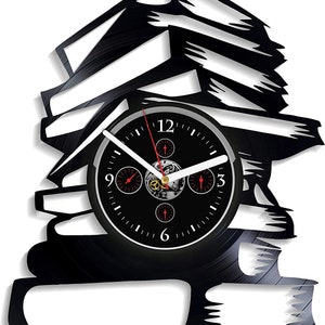May include: A black wall clock shaped like a stack of books. The clock face is black with white hands and red accents. The clock is made from a vinyl record and has a unique, artistic design.