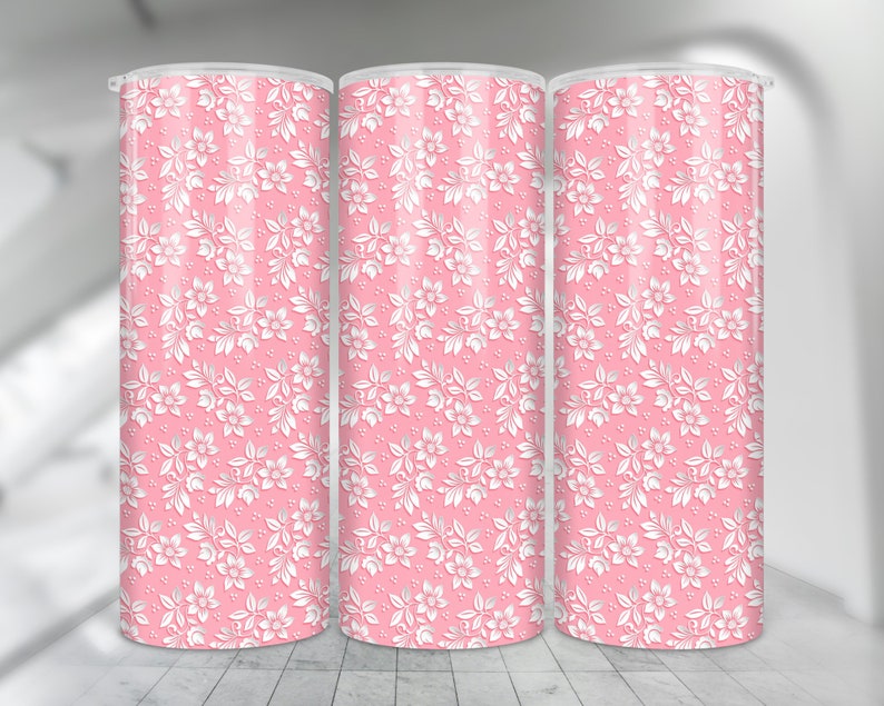 May include: Three pink tumblers with a white floral pattern. The tumblers are made of stainless steel and have a double-wall construction to keep drinks cold or hot.