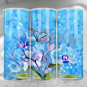 May include: A set of three blue and white tumbler cups with a design of blue orchids and butterflies on a blue glitter background.