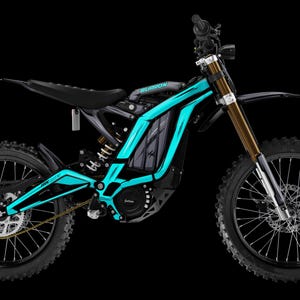 Può includere: Una moto da cross elettrica nera con elementi grafici turchese brillante. Le forcelle delle sospensioni sono dorate e la moto ha una sella e pneumatici neri. La parola "Surron" è visibile sul telaio.