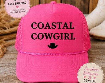 Könnte beinhalten: Eine leuchtend pinke Trucker-Cap mit Schaumstoff-Vorderseite und Netzrückseite. Der Text COASTAL COWGIRL ist in Schwarz auf der Vorderseite aufgedruckt, ergänzt durch ein kleines schwarzes Cowboyhut-Symbol unter dem Text. Mit passender pinker Kordel.