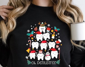 May include: Black sweatshirt with a Christmas tree design made of teeth. The tree is decorated with ornaments, candy canes, and a snowman. The text "Oh Denustree" is printed below the tree.