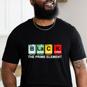 May include: Black t-shirt with the word "BLACK" spelled out using periodic table elements. The text "THE PRIME ELEMENT" is below the word. The letters are in different colors: blue, green, yellow, and red.