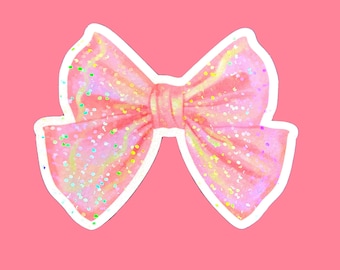 May include: A pink sparkly bow with a white outline. The bow is made of a soft, shimmery fabric with a subtle iridescent sheen.