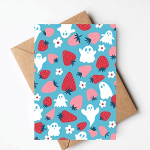 May include: A blue card with a repeating pattern of white ghosts and red and pink strawberries.