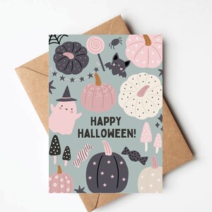 May include: A light blue card with a happy Halloween greeting. The card is decorated with a variety of Halloween-themed illustrations, including pumpkins, ghosts, bats, sweets, and stars.