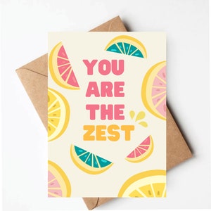 May include: A greeting card with a yellow background and a pattern of pink, yellow, and blue lemon slices. The text "You are the Zest" is written in pink, yellow, and orange letters.